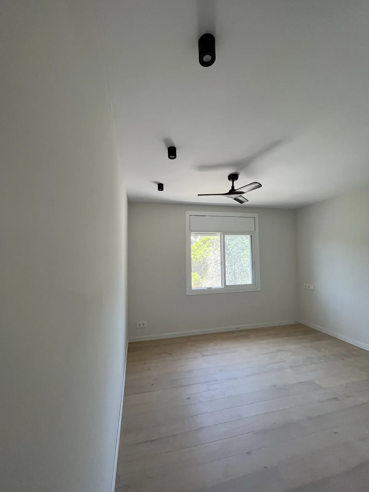 Dormitori amb parquet de roure, focus encastats i ventilador de sostre, casa Priorat a Alella